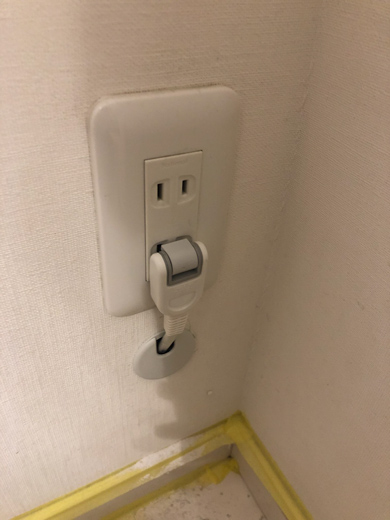 壁コンセントに穴から伸びている延長コードを差す