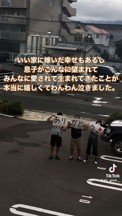 夫と義両親が札を持ち揺れているところ