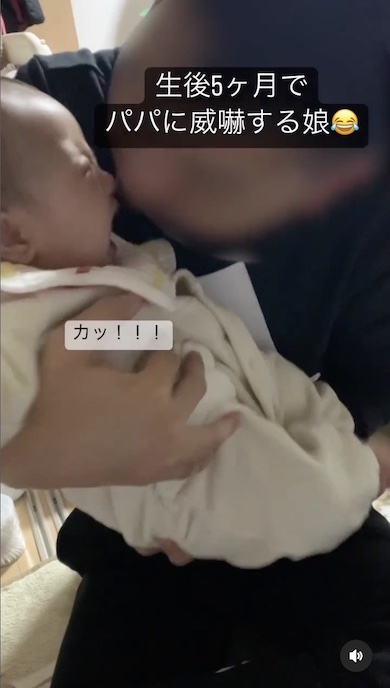 パパに噛みつこうとする赤ちゃんの写真