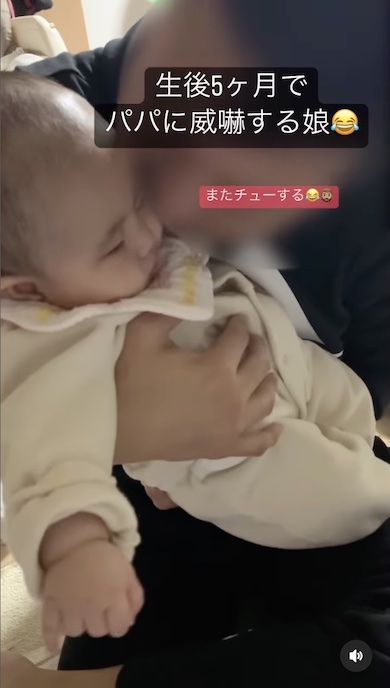 赤ちゃんにチューしようとするパパの写真