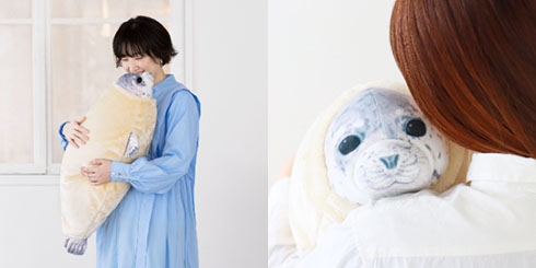 エビフライアザラシのクッションを抱く人