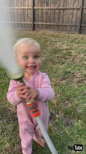 「Daughter Sprinkles Water on Dad With Hose - 1402277」