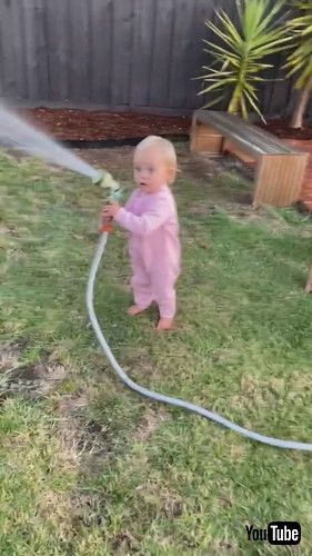 「Daughter Sprinkles Water on Dad With Hose - 1402277」