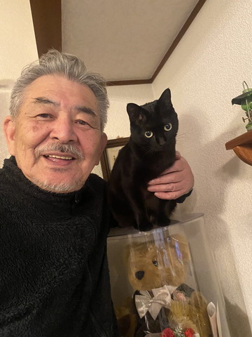 人形ケースの上にいる猫とお父さん