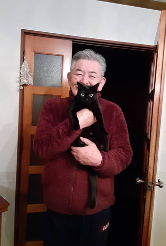 赤いフリース着て猫抱っこするお父さん