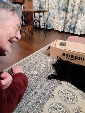 寝転がる猫と笑顔のお父さん