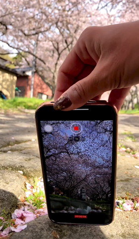 携帯を手前に軽く引いてる