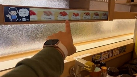 はま寿司の寿司が回るタッチパネルを押そうとしているところ