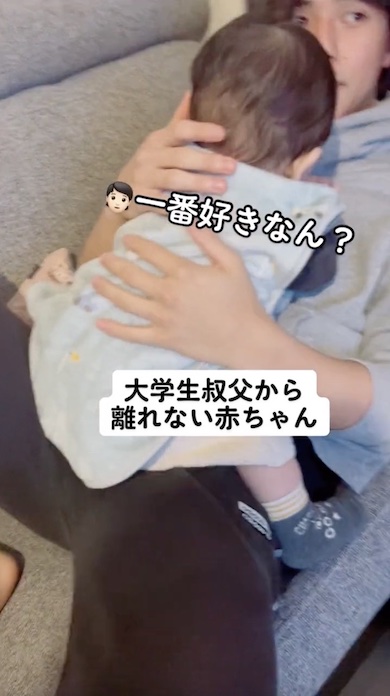 大学生の叔父に顔を埋めて甘える赤ちゃんの写真