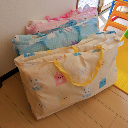 三つ子たちの保育園の荷物を全部背負った写真
