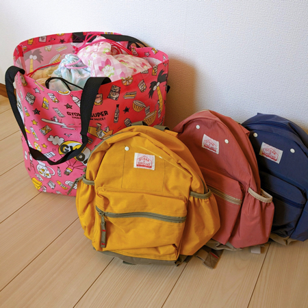 三つ子たちの保育園の荷物を全部背負った写真