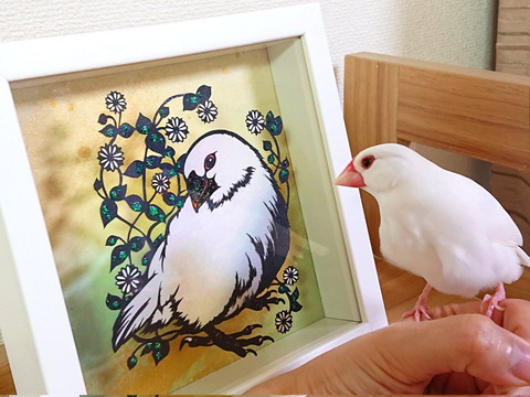 切り絵を見る文鳥