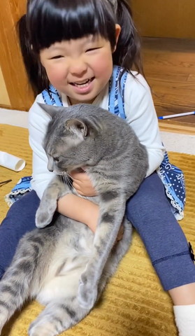 猫を抱きしめて笑顔の女の子