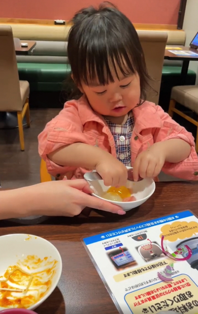 つるつるのゼリーと格闘する2歳の女の子