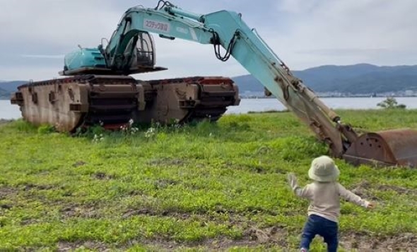 巨大な重機を見つけた男の子の画像