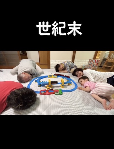 プラレールを同じ目線で見つめる家族の写真