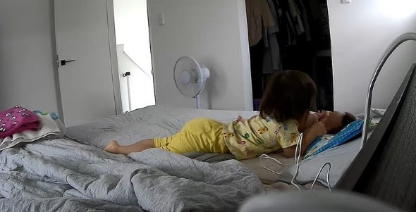 弟の横で添い寝をする画像