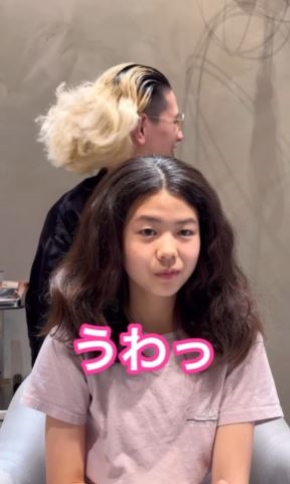 髪の毛をほどいて見せる紫藤さんの画像