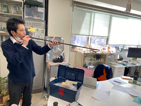 吹き矢を拭く小池先生