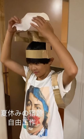 頭の上のトイレットペーパーをちぎる画像