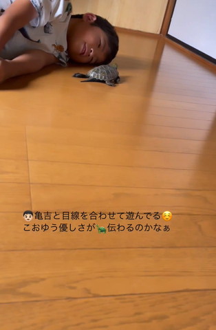 寝転がってカメとあそぶ息子さん遠くから