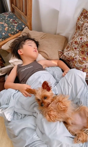 息子の足元で寝そべるワンコ