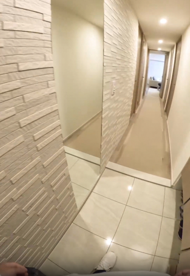 玄関のドアを開けた瞬間リビングから顔を出すミニチュアシュナウザー