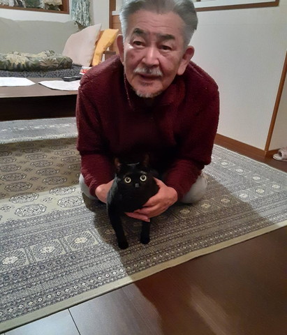 手で猫をつかむお父さん