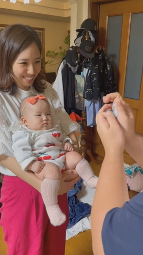 冴香さんが赤ちゃんを抱っこしてお兄さんがあやしているところ