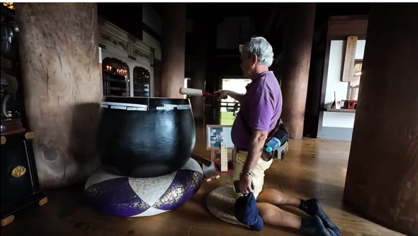 大きなりんを鳴らす体験をするコロンビア人のお父さん