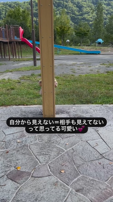 柱の後ろにかくれる2歳の女の子