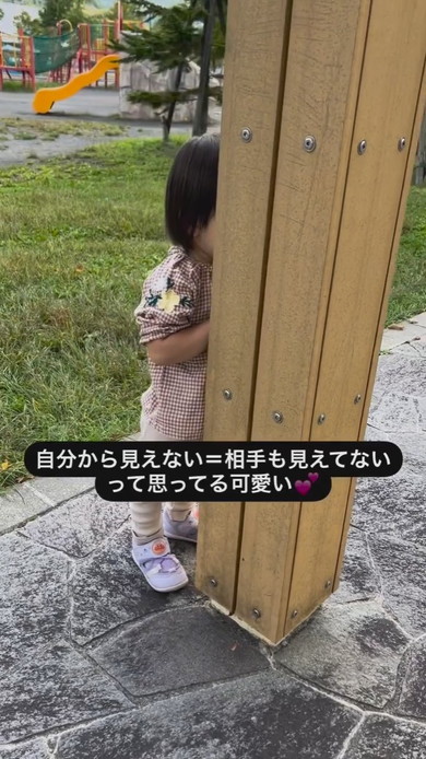 柱の後ろにかくれる2歳の女の子