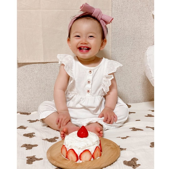 ケーキを前に笑う1歳の女の子