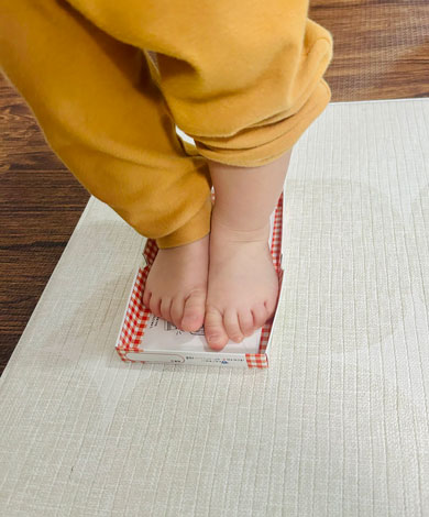 クーピーの箱に足を突っ込む子ども