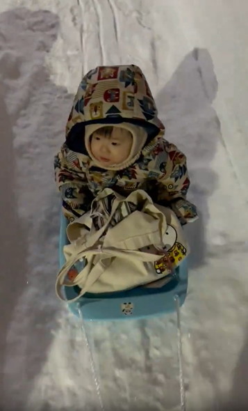 そりに乗る子供