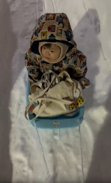 そりに乗る子供