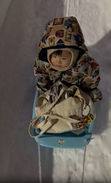 そりに乗る子供