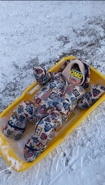 ソリで寝転がる子供