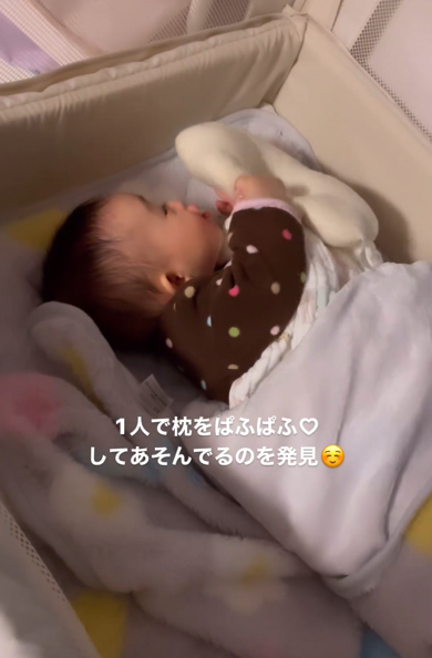 枕を自分のほっぺにぱふぱふして遊ぶ赤ちゃん