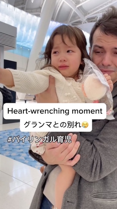 父に抱かれ手を伸ばして泣いている女の子