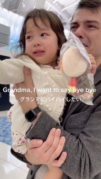 父に抱かれ手を伸ばして泣いている女の子