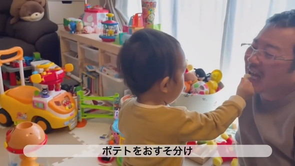 ポテトをおじいちゃんにおすそ分けする1歳の男の子