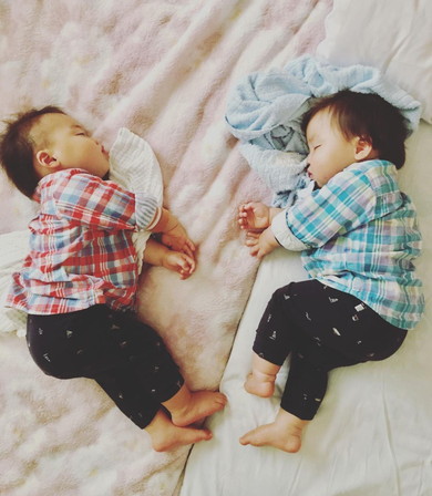 向き合って眠る1歳の双子男児