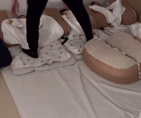 三つ子に優しく毛布をかけるパパ