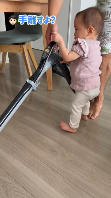 掃除機の取っ手を持つ女の子