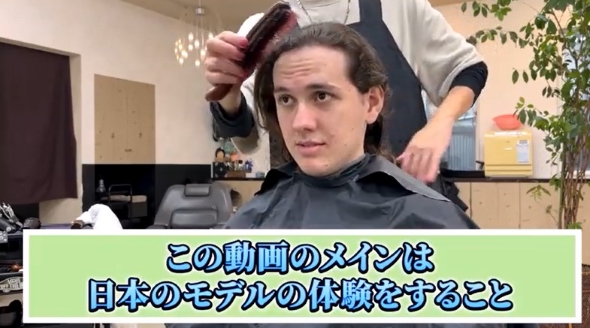 美容師に髪をとかしてもらう青年