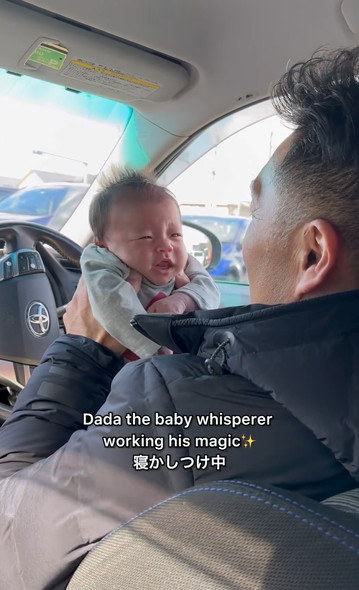 赤ちゃんを寝かしつけるパパ