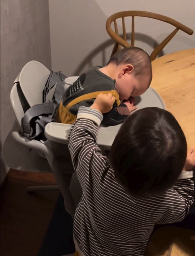 眠っている弟を揺さぶる兄