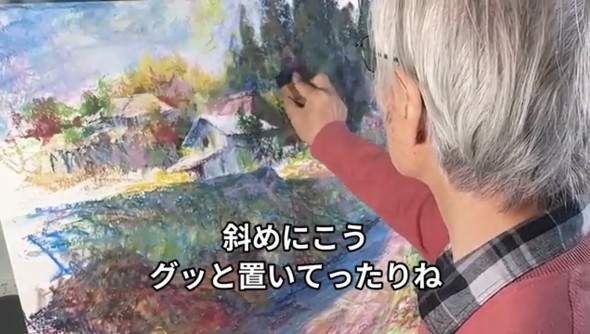 クレヨンの角を使って絵に動きを出す柴崎さん