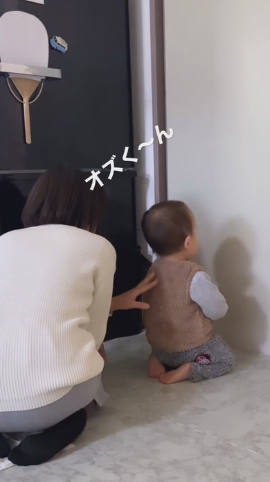 すねて正座し壁を向いている1歳児